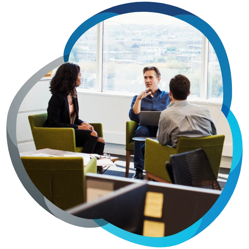 A woman and two men sitting in armchairs in an office talking to each other